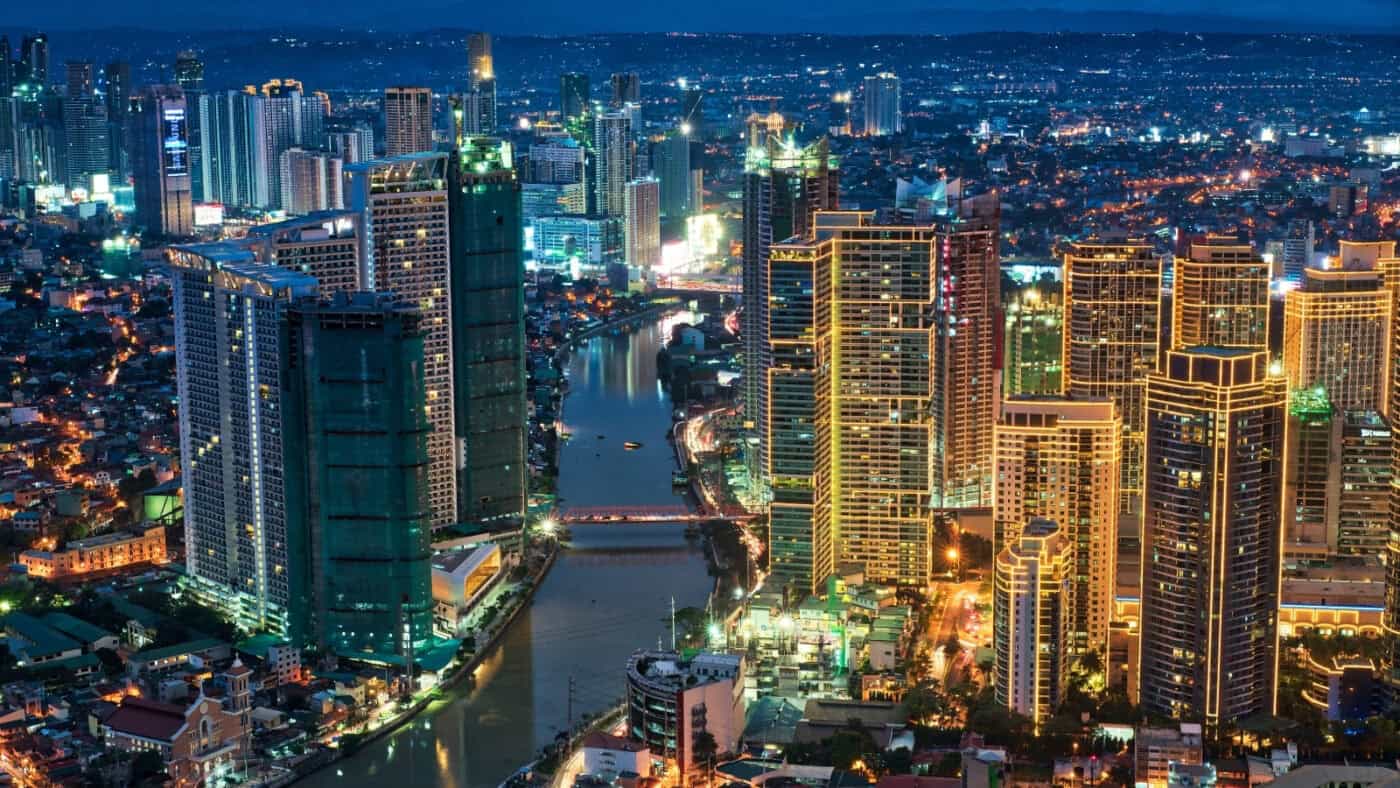 Manila skyline at night near the Pasig River, highlighting things to do in Manila
