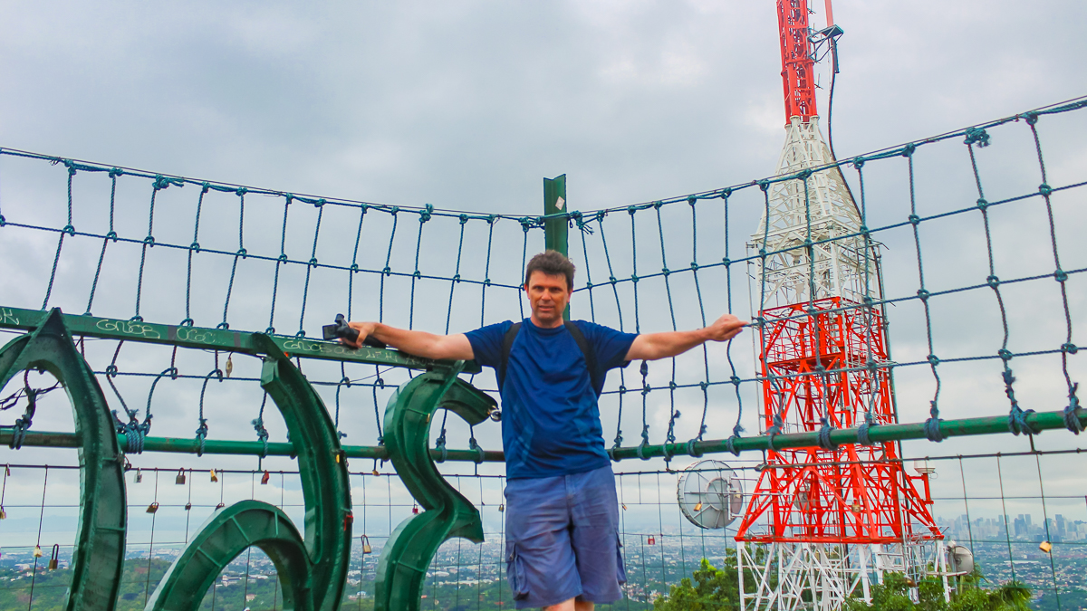 Visitor posing beside the Cloud 9 Antipolo hanging bridge with the communications tower in the background.