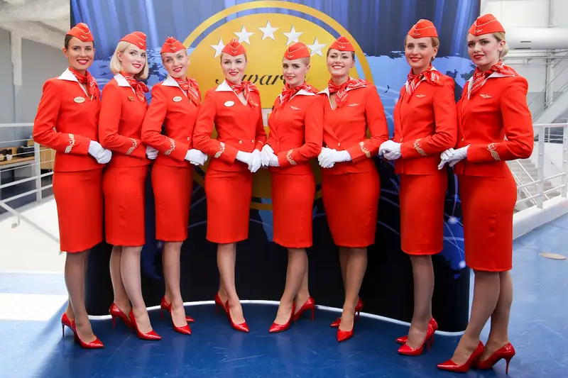 Hot air hostess Aeroflot cabin crew in red uniform with precise grooming and coordinated stance