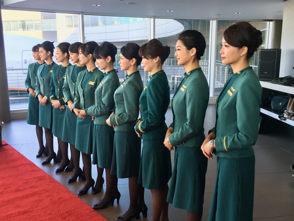 Hot air hostess EVA Air cabin crew in green uniform standing in formation, showing discipline, composure, and controlled presentation in airline service