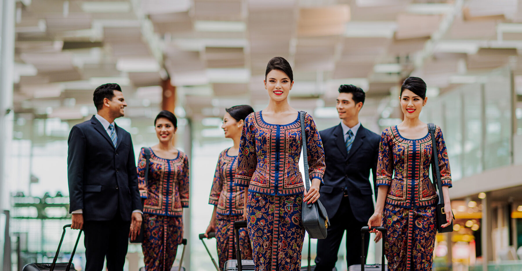 Hot air hostess Singapore Airlines cabin crew in sarong kebaya uniform walking through airport with composed and professional presence