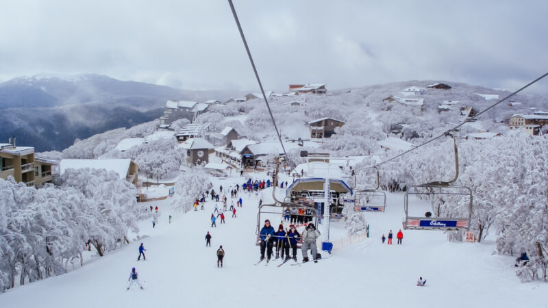 Australian Alps winter village with snow-covered mountains, chairlifts and skiers in Australia's Snowy Mountains