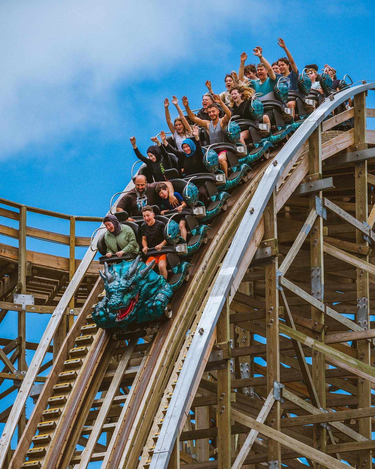 "Thrilled riders on a dragon-themed roller coaster at SeaWorld Gold Coast, enjoying a high-speed adventure under a clear blue sky.