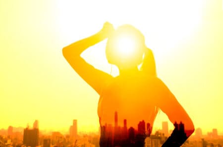 Traveller shielding eyes under intense sunlight in the Philippines, highlighting extreme heat and heatstroke risk for tourists