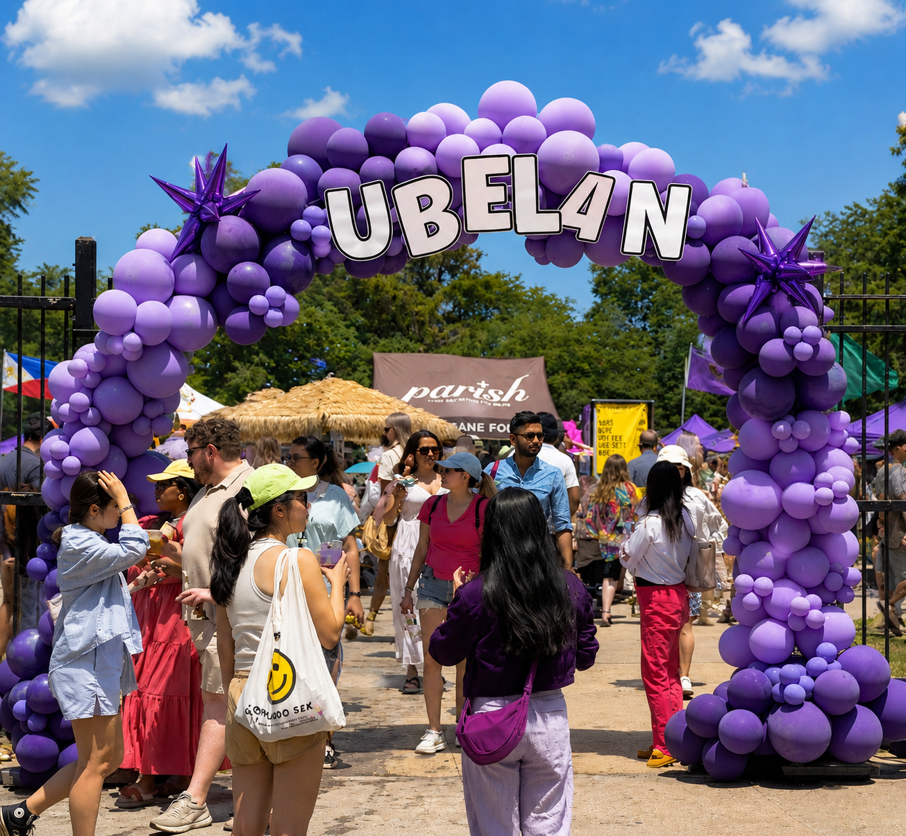 Visitors entering an ube-themed festival through a large purple balloon arch surrounded by food stalls and crowds celebrating Filipino ube culture.
