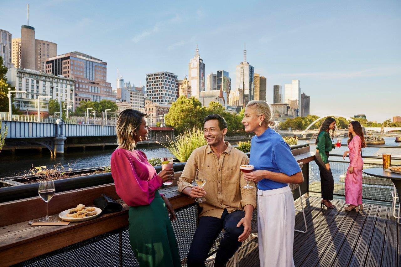 Group of people having a casual conversation at a rooftop bar in Melbourne, Australia, illustrating Australian slang in real-life informal Australian communication and everyday social speech culture.