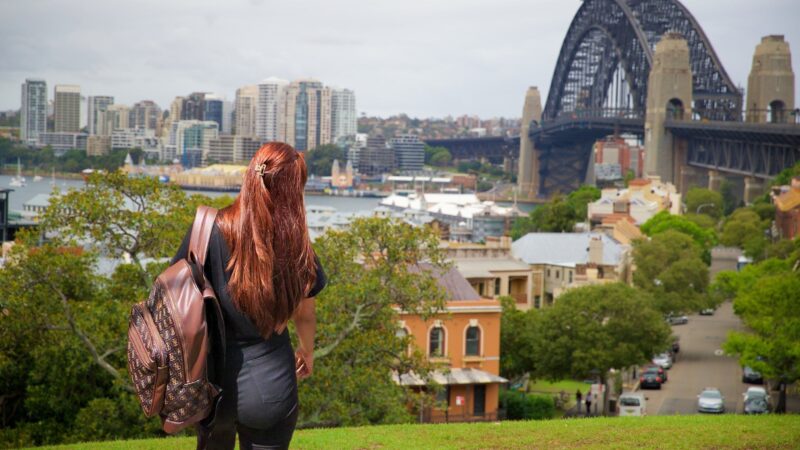 A traveller overlooking Sydney's Harbour Bridge and historic Millers Point neighbourhood, representing the experience of living in Australia
