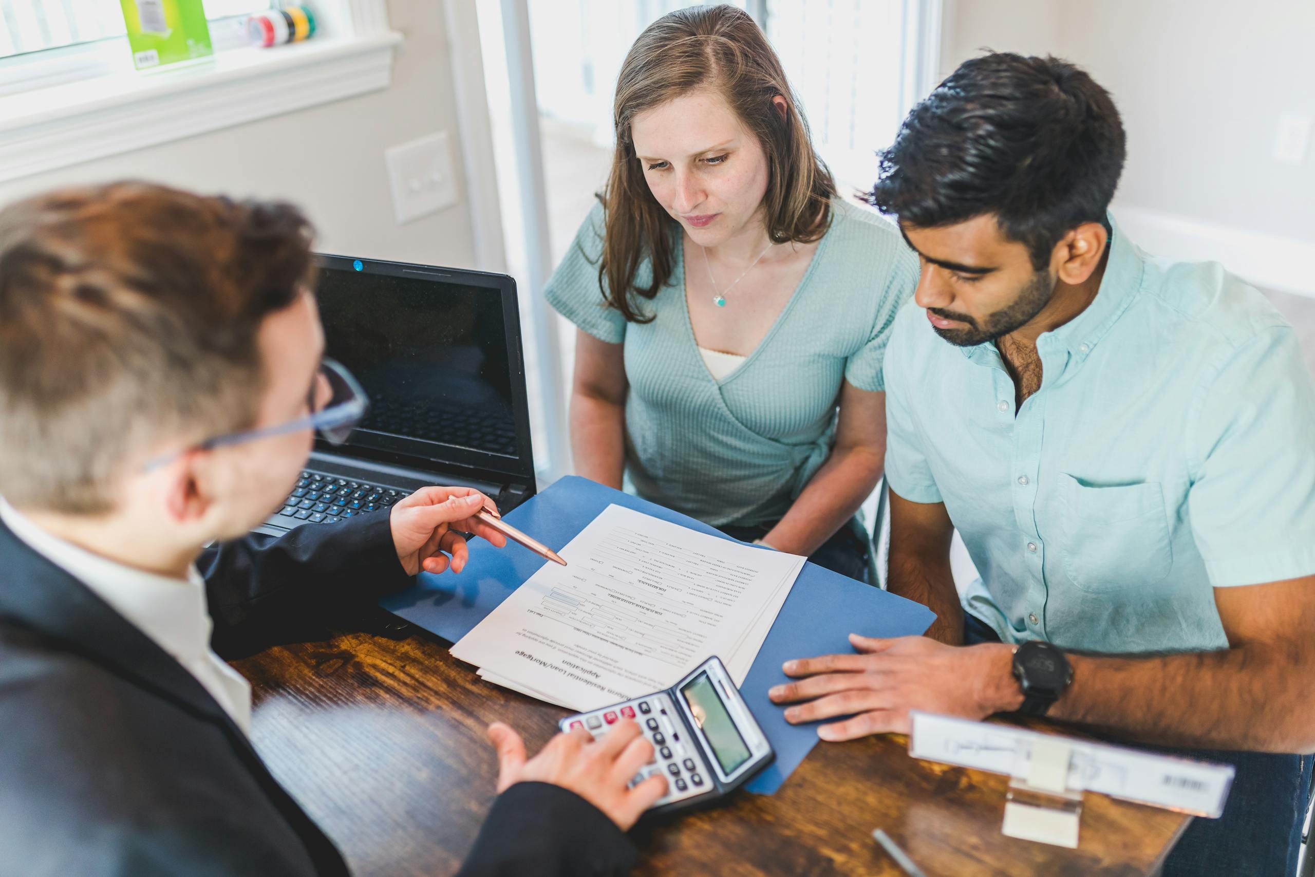 Renting in Australia as a migrant — a couple reviewing a rental application with a property manager, navigating the documentation process without Australian rental history