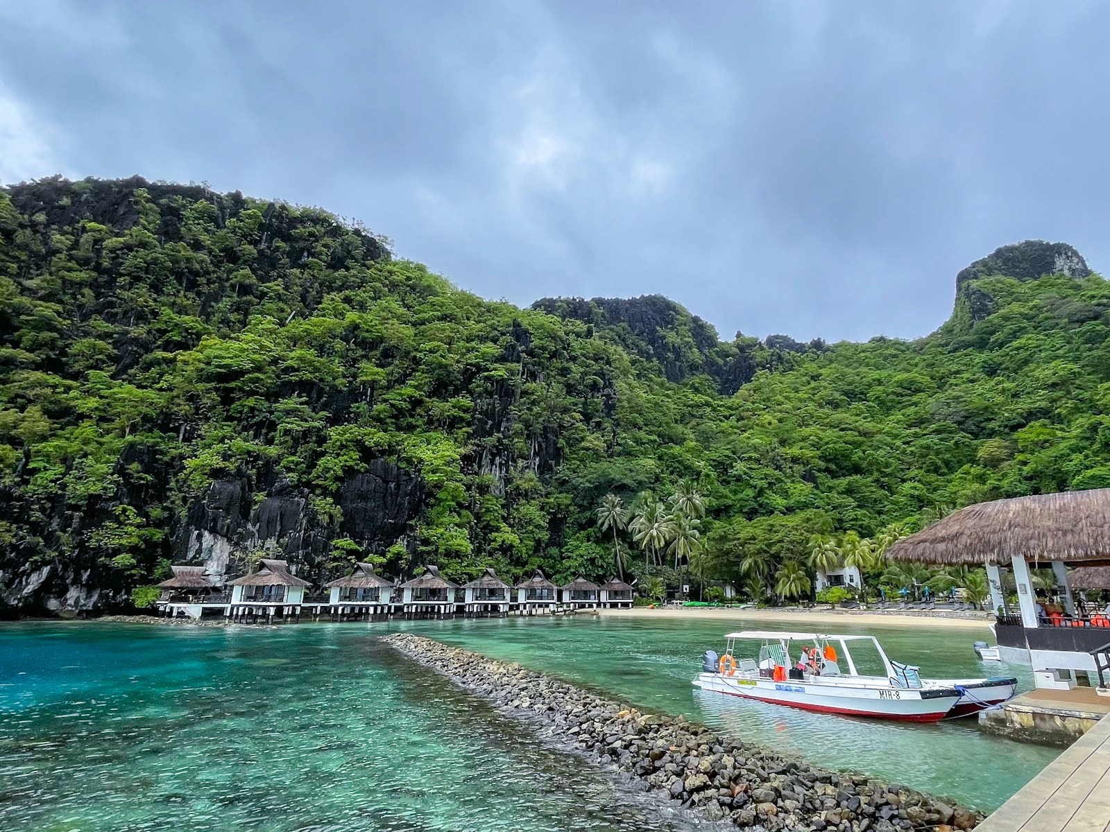 Island resort beneath limestone cliffs on a Palawan beach