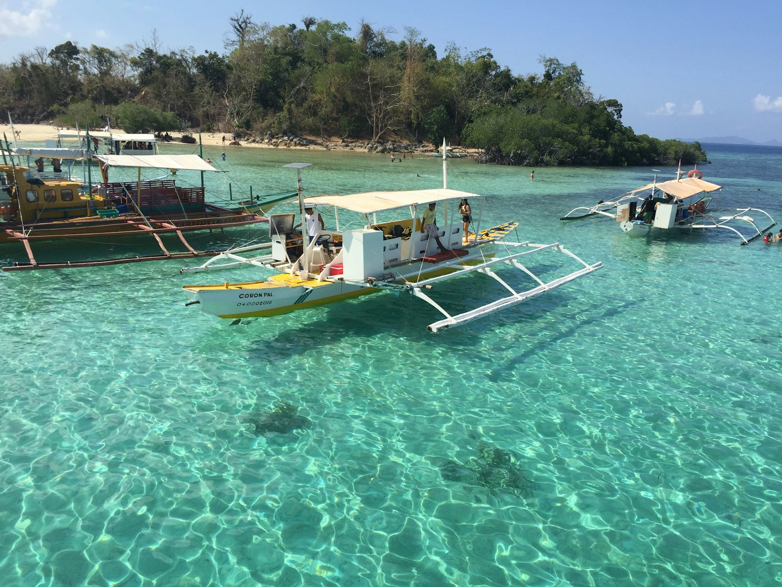 Outrigger boats anchored in turquoise water off Coron Town, Palawan